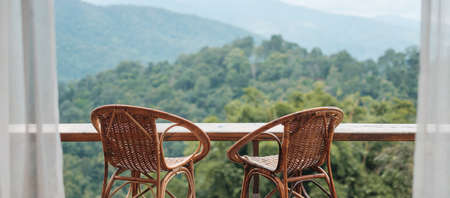 Couple chairs on balcony of countryside home or homestay with mountain view background in the morningの写真素材