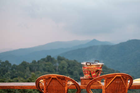 Pork or meat with vegetables and soup on the hot pan against mountain view background, Traditional Thai BBQ style is famous in Thailandの写真素材