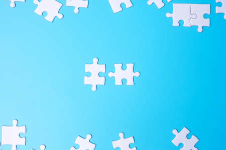 Group of white puzzle jigsaw pieces on blue background. Concept of solutions, mission, success, goals, cooperation, partnership, strategy and puzzle dayの写真素材
