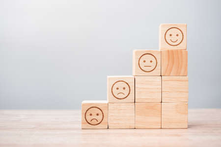 emotion face symbol on wooden blocks. Service rating, ranking, customer review, satisfaction, evaluation and feedback conceptの写真素材