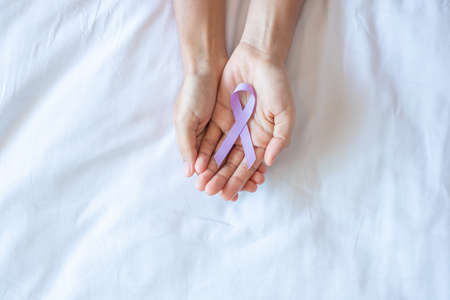 World cancer day (February 4). Woman hand holding Lavender purple ribbon for supporting people living and illness. Healthcare and medical conceptの写真素材