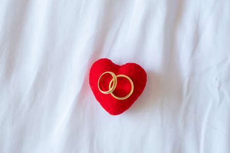 heart shape decoration and couple golden engagement ring on white background. Love, together and Happy Valentines day conceptの写真素材