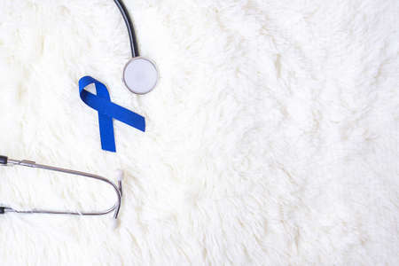 March Colorectal Cancer Awareness month, dark Blue Ribbon with stethoscope on white background for supporting people living and illness. Healthcare, hope and World cancer day conceptの写真素材