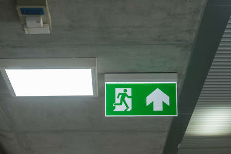 Fire Emergency exit sign on the wall inside building at subway train station. Safety conceptの写真素材