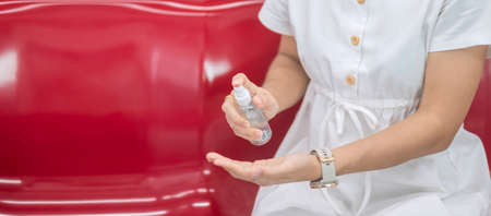 woman clean hand by alcohol spray sanitizer in train or public transportationの写真素材