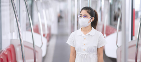 woman wearing Medical face mask and listening music by earphones in train.の写真素材