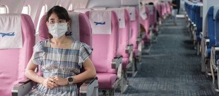 Young woman wearing protective face mask in airplane or public transportation, protection  disease infection, Asian tourist ready to travel. Next Normal and reopening conceptの写真素材