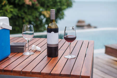 Two Red wines glasses near swimming pool. Summer travel, vacation, holiday and happy weekend conceptの写真素材