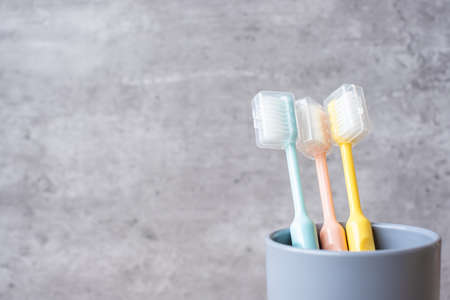 Set of Toothbrushes in cup on wall background at bathroom. World oral health day and free dental day...