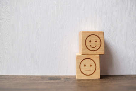 emotion face symbol on wooden blocks. mood, Service rating, ranking, customer review, satisfaction, evaluation and feedback conceptの写真素材