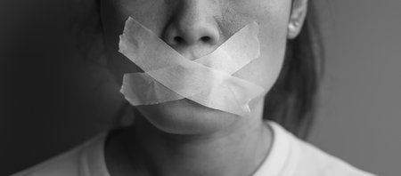 woman with mouth sealed in adhesive tape. Free of speech, freedom of press, Human rights, Protest dictatorship, democracy, liberty, equality and fraternity conceptsの写真素材