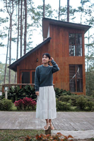 Happy woman in sweater traveling in pine tree forest, tourist visit at Doi Bo Luang, Chiang Mai, Thailand, Landmark and popular for tourist attractions. Vacation and journey conceptの写真素材