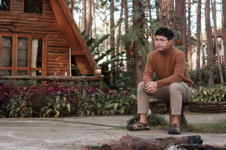 Happy man in sweater traveling in pine tree forest, tourist visit at Doi Bo Luang, Chiang Mai, Thailand, Landmark and popular for tourist attractions. Vacation and journey conceptの写真素材