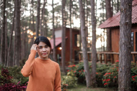 Happy woman in sweater traveling in pine tree forest, tourist visit at Doi Bo Luang, Chiang Mai, Thailand, Landmark and popular for tourist attractions. Vacation and journey conceptの写真素材