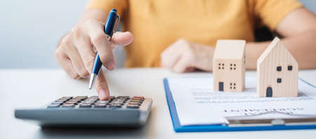 Woman using calculator during signing home contract documents. Contract agreement, real estate,  buy and sale and insurance conceptsの写真素材