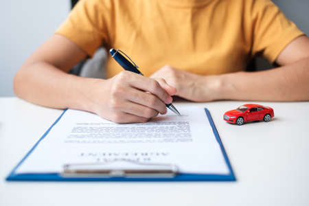 woman hand signing contract document. buy and sale, insurance, car rental and contract agreement...