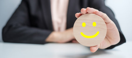 hand holding smile face block. Customer choose Emoticon for user reviews. Service rating, ranking,...