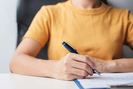 Woman signing on contract documents after reading, hand holding pen and approve on business report....