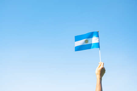 hand holding Argentina flag on nature background. 9th July of Independence day, 25th May of Revolution day and happy celebration conceptsの写真素材