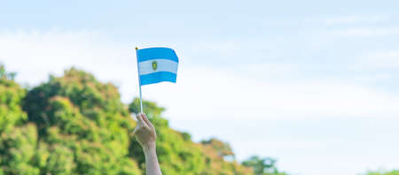 hand holding Argentina flag on nature background. 9th July of Independence day, 25th May of Revolution day and happy celebration conceptsの写真素材