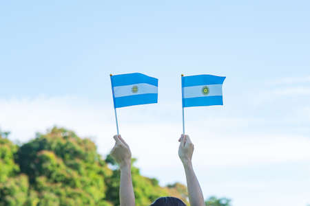 hand holding Argentina flag on nature background. 9th July of Independence day, 25th May of Revolution day and happy celebration conceptsの写真素材