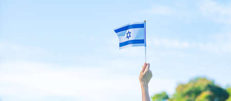 hand holding Israel flag on nature background. Israel Independence day and happy celebration conceptsの写真素材