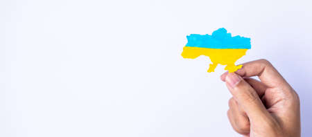 Support for Ukraine in the war with Russia, Hands holding the shape of Ukraine border with color flag. Pray, No war, stop war and stand with Ukraineの写真素材