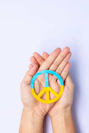 Support for Ukraine in the war with Russia, Hands holding symbol of peace with flag of Ukraine. Pray, No war, stop war, stand with Ukraine and Nuclear Disarmamentの写真素材