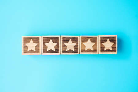 star symbol block on blue background. Service rating, ranking, customer review, satisfaction, evaluation and feedback conceptの写真素材