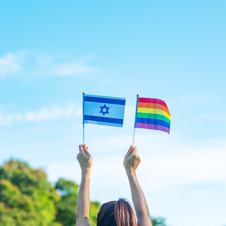 hands showing LGBTQ Rainbow and Isarael flag on nature background. Support Lesbian, Gay, Bisexual, Transgender and Queer community and Pride month conceptの写真素材