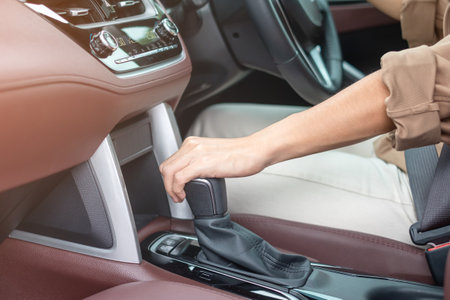 woman driver stick shift transmission a car gear, hand controlling steering wheel during vehicle...