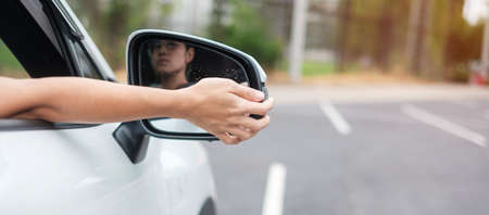 woman driver adjusting side view mirror a car. Journey, trip and safety Transportation conceptsの写真素材