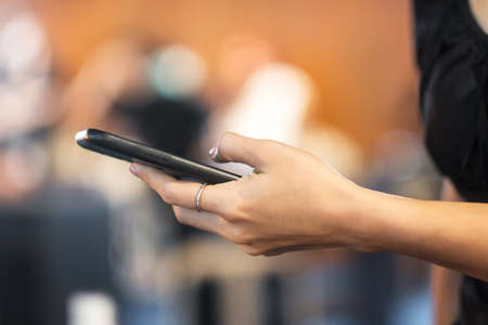 smartphone for sms messages, young woman typing touchscreen mobile phone in cafe or modern office....