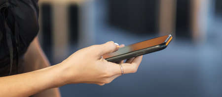smartphone for sms messages, young woman typing touchscreen mobile phone in cafe or modern office....