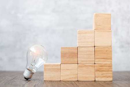 Lightbulb and wood block stack of building with business idea, creative, thinking goal, strategy and innovation conceptの写真素材