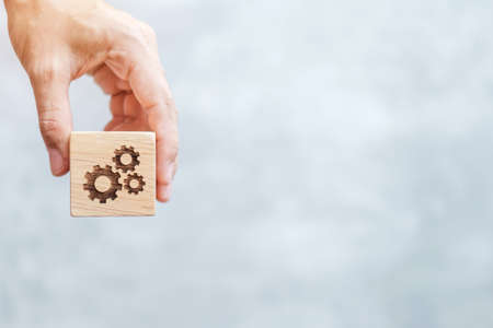 hand hold gear block with business goal, strategy, teamwork, target, mission, action, objective,...