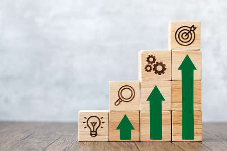 wood block stack of building with rise graph. business growth, goal, strategy, target, mission,...