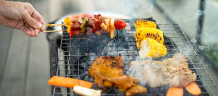 delicious grilled meat with smoke, BBQ with vegetables in outdoor. Barbecue, Party, lifestyle and picnic conceptの写真素材