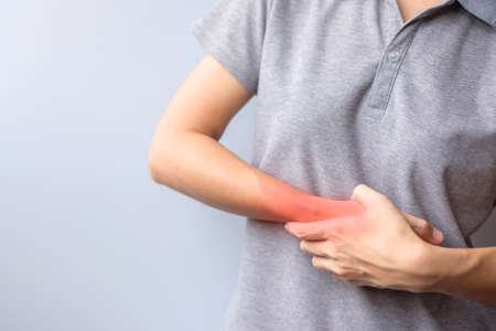 woman holding her wrist pain because using smartphone or computer long time. De Quervain s...