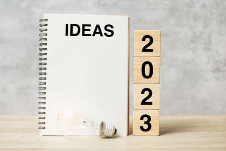 2023 text wood cube blocks and IDEAS word with lightbulb on table. New Year New Ideas, Creative, Innovation, Imagination, inspiration, Resolution, Strategy and goal conceptの写真素材
