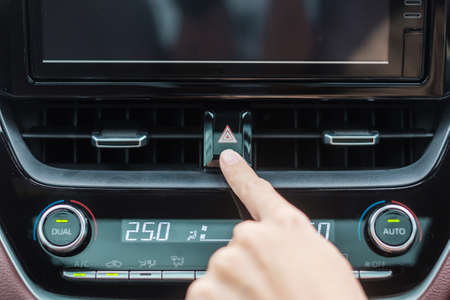 Finger presses the emergency stop button inside the car. Safety and transportation concept