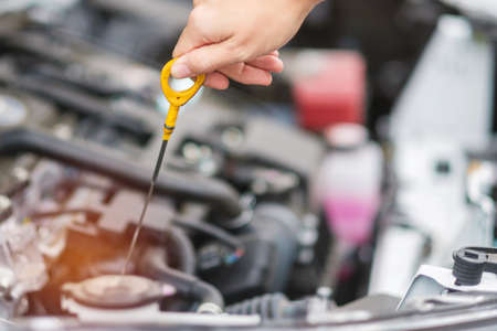 woman hand  check oil level in car engine. Self Maintenance, repair and problem conceptの写真素材