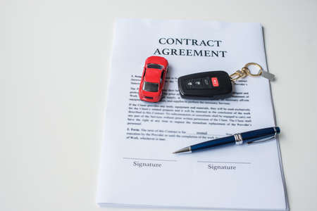 contract document with car and remote key. buy and sale, insurance, rental and contract agreement conceptsの写真素材