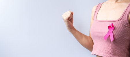Pink October Breast Cancer Awareness month, woman hand hold pink Ribbon and wear shirt for support people life and illness. National cancer survivors month, Mother and World cancer day conceptの写真素材