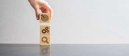 wood block with business goal, strategy, target, mission, action, objective, teamwork, brainstorm...