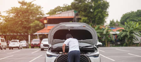 man driver standing near a problem car. Breakdown or broken car on road. Vehicle Insurance,...