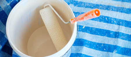 paint roller brush with bucket during painting the wall. Renovation, maintenance and development of home or apartmentの写真素材