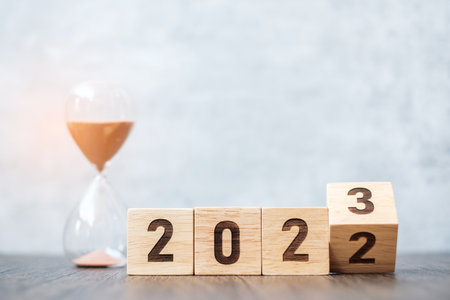 flip block 2022 to 2023 text with hourglass on table. Resolution, time, plan, goal, motivation, reboot, countdown  and New Year holiday conceptsの写真素材