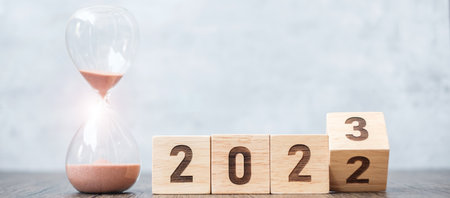flip block 2022 to 2023 text with hourglass on table. Resolution, time, plan, goal, motivation,...