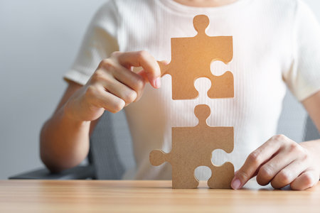Hand connecting couple puzzle piece. Business Solving, mission, challenge, success, goals, target and strategy conceptsの写真素材
